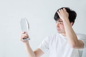 鏡を見る男性